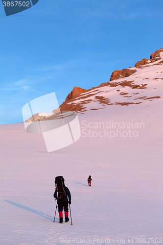 Image of Two hikers in sunrise snowy plateau