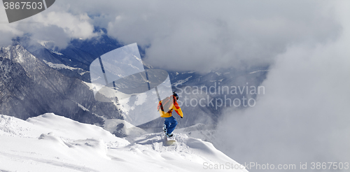 Image of Snowboarder on off-piste slope an mountains in fog