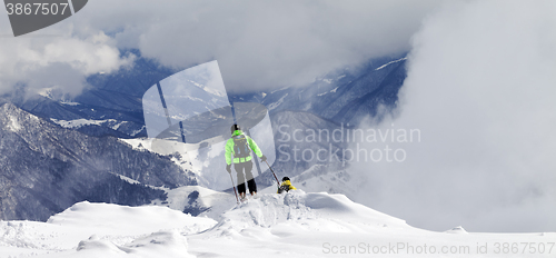 Image of Freeriders on off-piste slope and mountains in mist