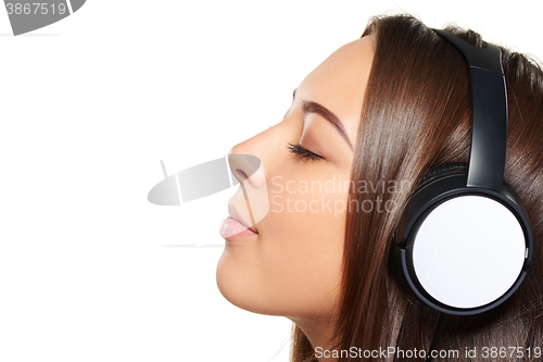 Image of Female listening enjoying music in headphones with closed eyes