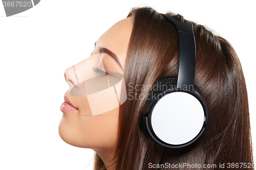 Image of Female listening enjoying music in headphones with closed eyes