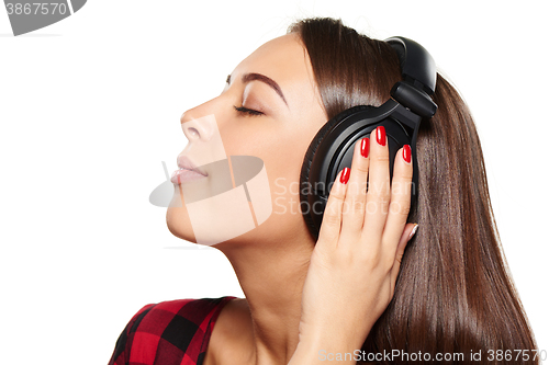 Image of Female listening enjoying music in headphones with closed eyes