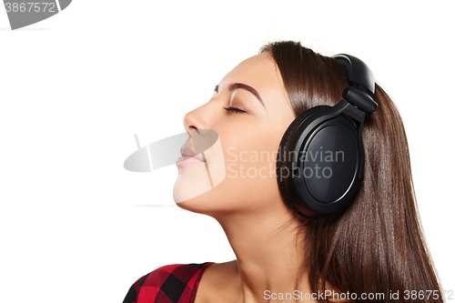 Image of Female listening enjoying music in headphones with closed eyes