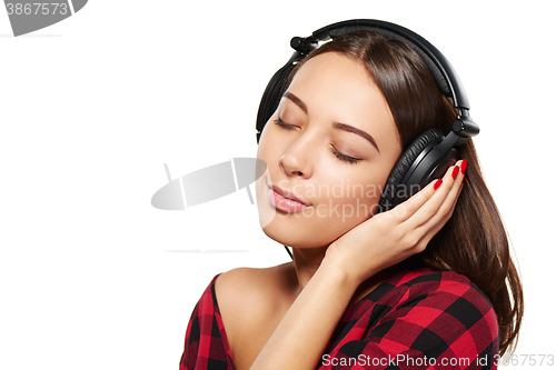 Image of Female listening enjoying music in headphones with closed eyes