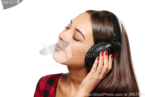 Image of Female listening enjoying music in headphones with closed eyes