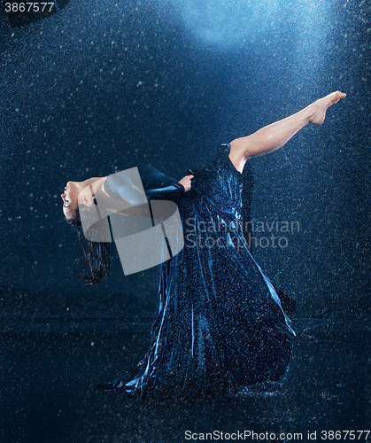 Image of The young beautiful modern dancer dancing under water drops