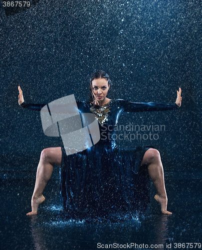 Image of The young beautiful modern dancer dancing under water drops