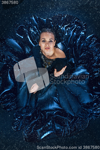 Image of The young beautiful modern dancer dancing under water drops