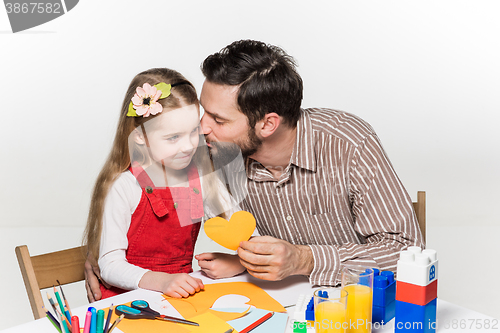 Image of The daughter and father carving out paper applications 