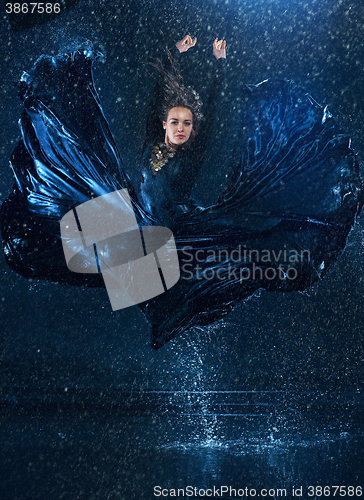 Image of The young beautiful modern dancer dancing under water drops