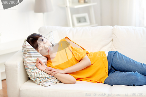 Image of happy asian teenage girl sleeping on sofa at home