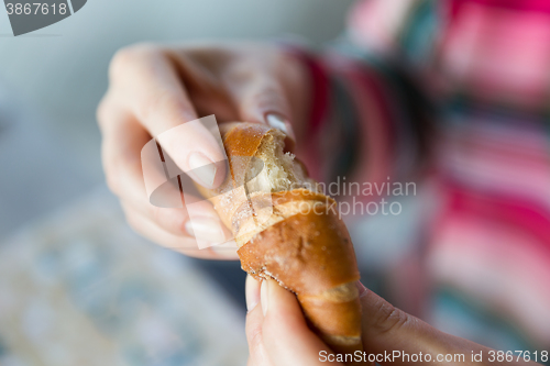 Image of close up of woman hands with bun or wheat bread