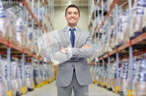 Image of happy man in suit and tie over warehouse