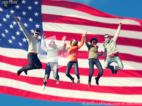 Image of smiling friends in sunglasses jumping high