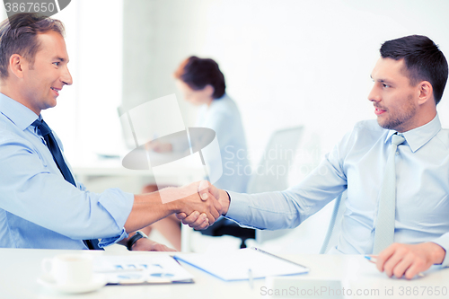 Image of businessmen shaking hands in office