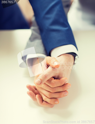 Image of close up of happy male gay couple holding hands