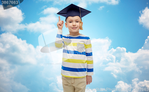 Image of happy boy in bachelor hat pointing finger up