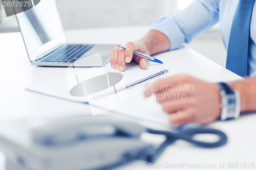 Image of businessman writing in notebook