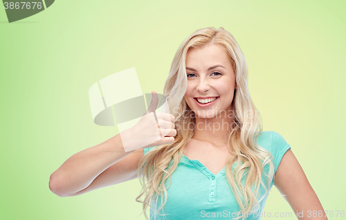 Image of happy woman or teenage girl showing thumbs up