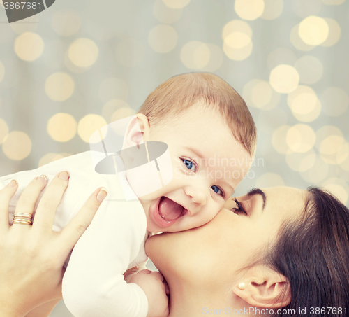 Image of happy mother with baby over lights background