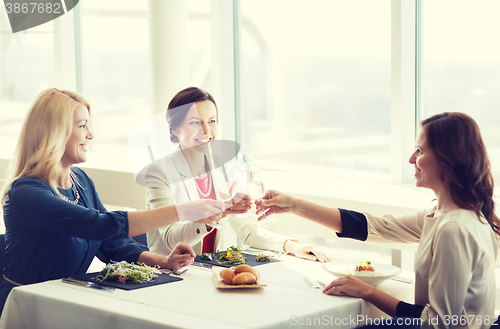 Image of happy women drinking champagne at restaurant