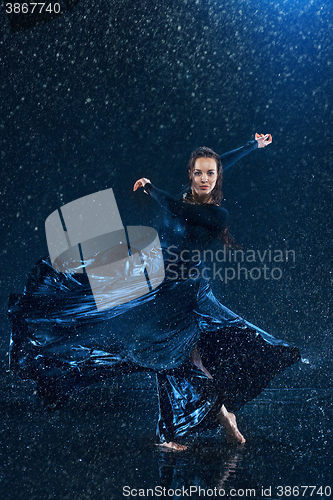 Image of The young beautiful modern dancer dancing under water drops