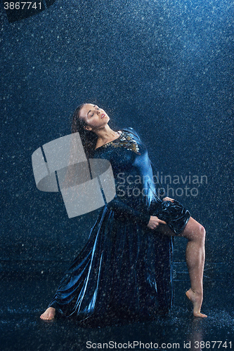 Image of The young beautiful modern dancer dancing under water drops