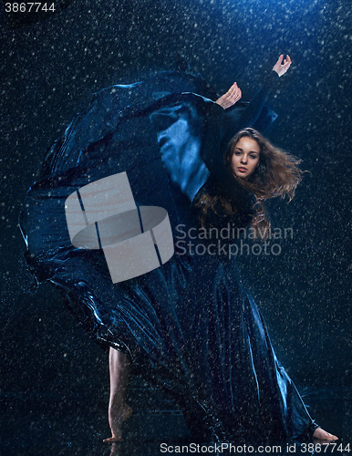 Image of The young beautiful modern dancer dancing under water drops