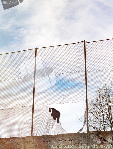 Image of Sweater hanging on the metal mesh fence