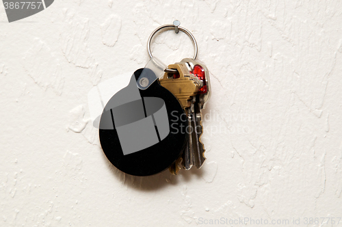 Image of three keys on wall with round blank black fob