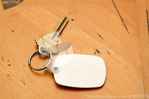 Image of Keyring with key and white fob on wood table