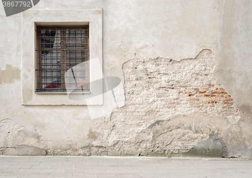 Image of abandoned cracked brick wall with a window