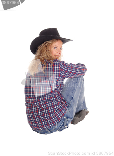 Image of Lovely woman sitting on floor with hat.