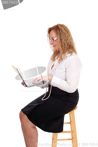 Image of Business woman sitting and working with laptop.