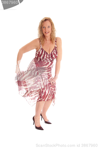 Image of Blond woman dancing in summer dress.