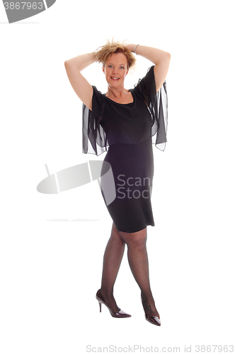 Image of Happy woman in black dress standing.