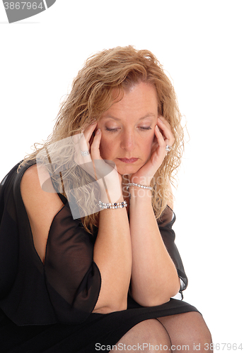 Image of A sad looking blond woman sitting.