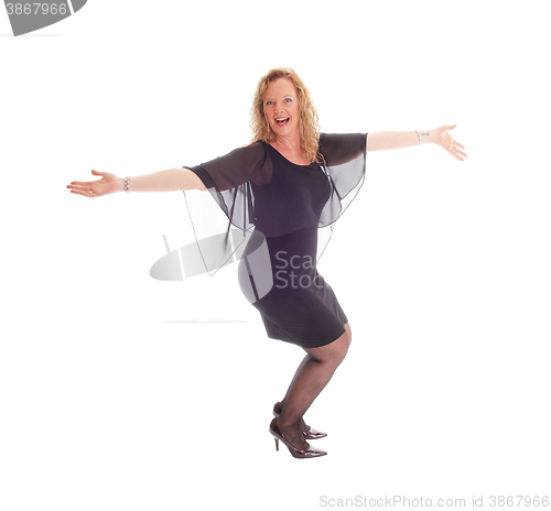 Image of Happy dancing woman in black dress.