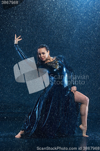 Image of The young beautiful modern dancer dancing under water drops