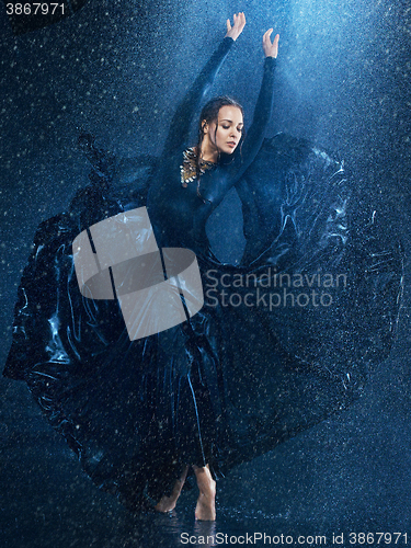 Image of The young beautiful modern dancer dancing under water drops