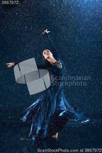 Image of The young beautiful modern dancer dancing under water drops