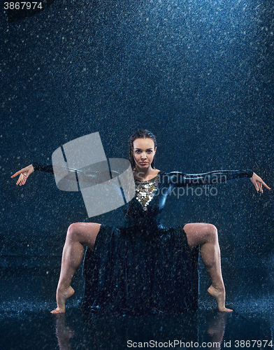 Image of The young beautiful modern dancer dancing under water drops