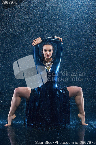 Image of The young beautiful modern dancer dancing under water drops