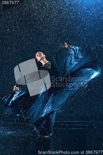 Image of The young beautiful modern dancer dancing under water drops