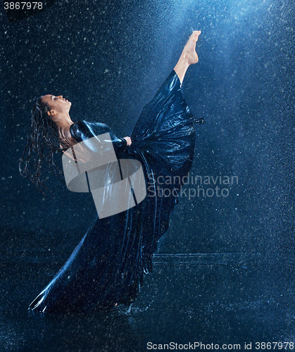 Image of The young beautiful modern dancer dancing under water drops