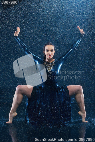 Image of The young beautiful modern dancer dancing under water drops