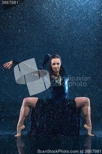 Image of The young beautiful modern dancer dancing under water drops