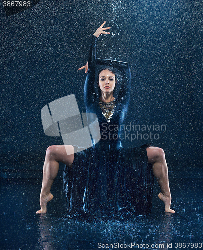 Image of The young beautiful modern dancer dancing under water drops