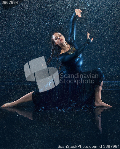 Image of The young beautiful modern dancer dancing under water drops