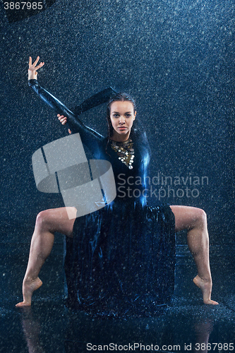 Image of The young beautiful modern dancer dancing under water drops